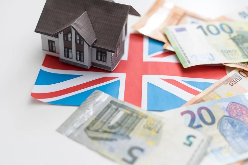 A picture of a small house and money on top of a flag.