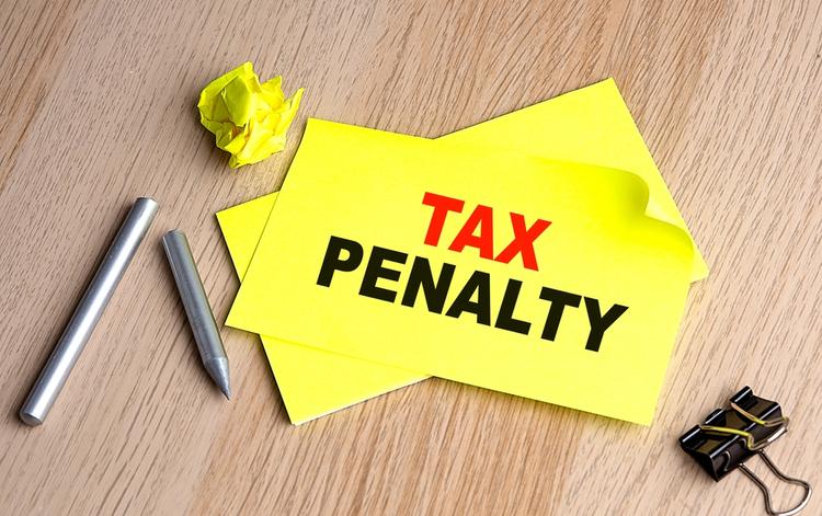 Yellow paper with the words "tax penalty" written on it