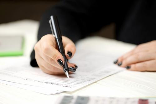 Woman holding a pen filling out a form